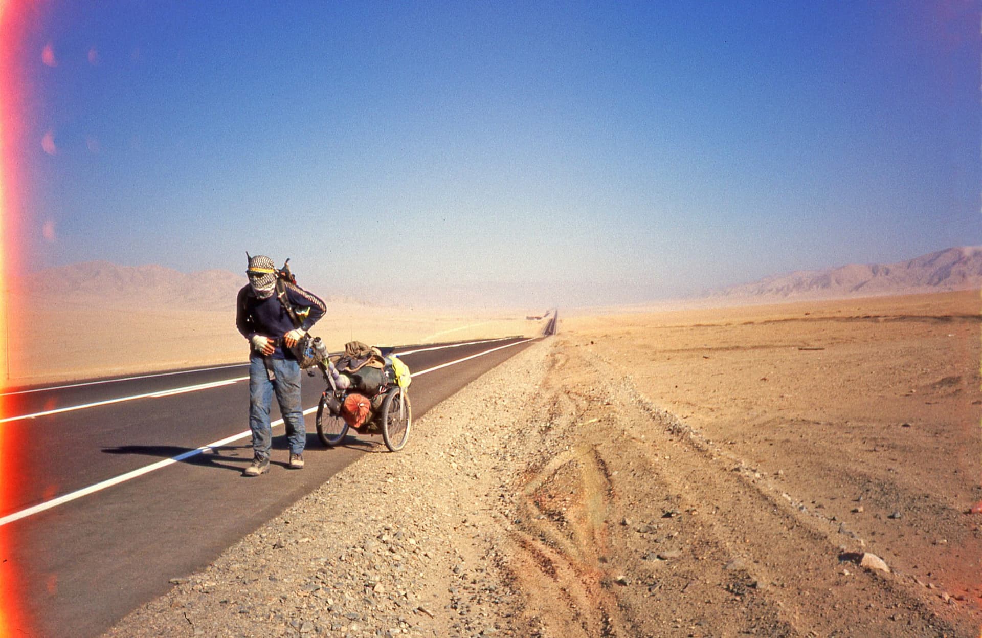 Karl Bushby in the early years of the walk, hauling his cart along an empty desert highway in South America.