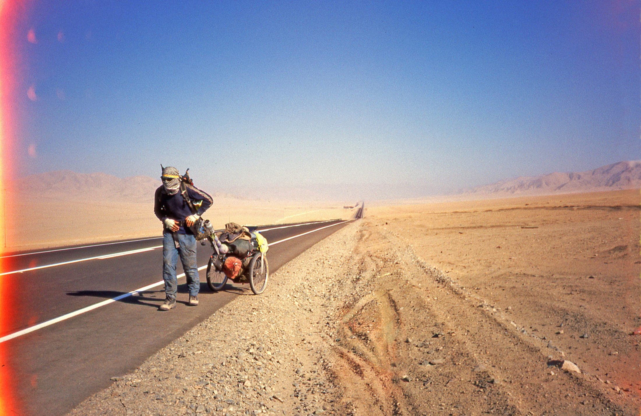 Karl Bushby in the early years of the walk, hauling his cart along an empty desert highway in South America.